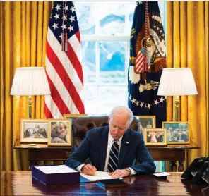  ?? (The New York Times/Doug Mills) ?? President Joe Biden signs the coronaviru­s relief package Thursday in the Oval Office. “This historic legislatio­n is about rebuilding the backbone of this country,” Biden said as he signed it.