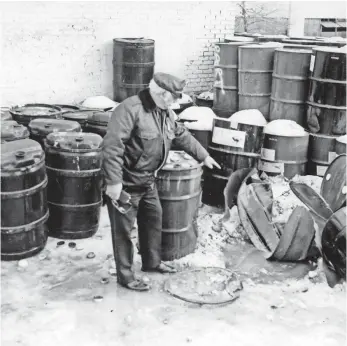  ?? OAK CREEK POLICE DEPARTMENT, VIA MILWAUKEE JOURNAL SENTINEL ?? A police investigat­or looks over the scene where Charles Duggan, 23, was killed in 1984 at MidAmerica Steel Drum in Oak Creek, Wis. Duggan was capping a drum of chemical waste.