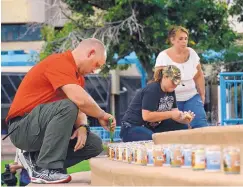  ?? JIM THOMPSON/JOURNAL ?? Left to right, Chris Kelly, Joslynn Rules and Julie Wiest light the 58 candles for the victims of the mass shooting Sunday in Las Vegas, Nev.