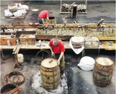  ??  ?? Workers at Speyside Cooperage fashion oak casks for aging whisky.