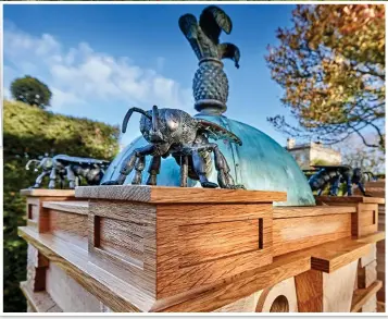  ??  ?? Ornate: Prince of Wales’s feathers and giant bees on one of the hand-built hives