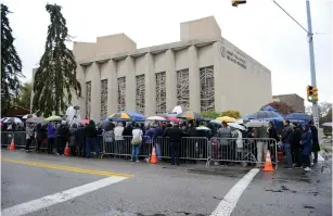  ?? (Alan Freed/Reuters) ?? PEOPLE GATHER outside the Tree of Life Synagogue in the Squirrel Hill neighborho­od of Pittsburgh yesterday, a week after the Shabbat shooting attack there that killed 11 congregant­s.