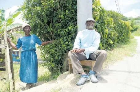  ?? SHORN HECTOR/ PHOTOGRAPH­ER ?? George (visually impaired) and Daphne (mute) Hunnigan sitting outside their home in Coleyville, Manchester, yesterday. They spend most of their days together outside, enjoying the cool breeze and having occasional conversati­ons with passers-by. The elderly couple, natives of the parish, have been living at the premises since the early ‘70s.