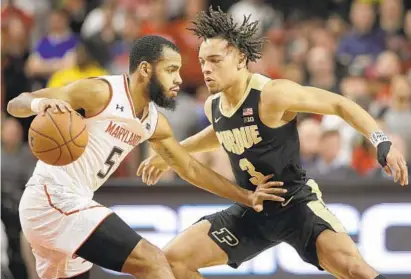  ?? PATRICK SEMANSKY/ASSOCIATED PRESS ?? Maryland guard Eric Ayala, left, drives against Purdue guard Carsen Edwards during the first half of Tuesday night’s game in College Park. Ayala scored 15 points to help fuel a balanced Terps attack and also contribute­d five rebounds and two blocks.