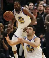  ??  ?? Golden State Warriors center Zaza Pachulia passes the ball against the Denver Nuggets during the first quarter of an NBA basketball game Saturday in Denver. PHOTO BY JACK DEMPSEY