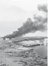  ?? THE NEW YORK TIMES ?? Smoke rises over a seaport
in Gaza City in July.