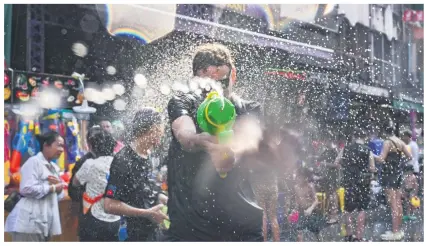  ?? PHOTO: AFP ?? Revellers take part in mass water fights on the eve of Songkran, or Thai New Year, on Khao San Road in Bangkok yesterday.