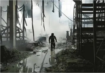  ?? GENYA SAVILOV/GETTY-AFP ?? A firefighte­r walks amid the ruins of a shopping mall hit by Russian shells Friday in Kherson, Ukraine.