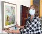  ?? BARB AGUIAR/Westside Weekly ?? Denise Reichman, chair of the Almost Spring Gallery display, hangs Barb Hanington's Beauty in the Spring.