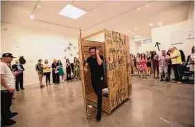  ?? ?? Italian artist Andrea Bianconi emerges from a wooden crate as part of the “Joureny of the Chair” exhibit at the Barbara Davis Gallery.