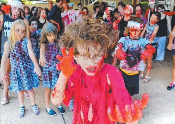  ?? Picture: PATRINA MALONE ?? Lindsay Balaam, of Ludmilla, leads a pack of terrifying zombies through Casuarina Square yesterday