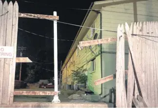  ?? [PHOTO BY ROBERT MEDLEY, THE OKLAHOMAN] ?? Below: Sgt. Dave Hollis tore down this fence to reach a window to rescue Tyree Polite, 2, who was dropped from the second floor by his mother during an apartment fire. The mother came out of windows on a ladder.