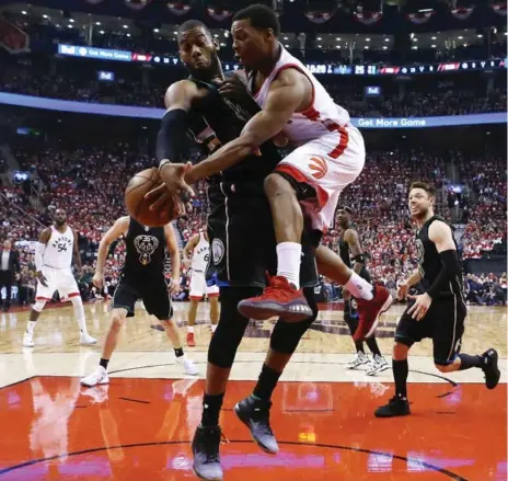  ?? STEVE RUSSELL/TORONTO STAR ?? Raptors guard Kyle Lowry, wrapping a pass around Milwaukee’s Greg Monroe, was doubtful to even play on Monday night because of back stiffness.