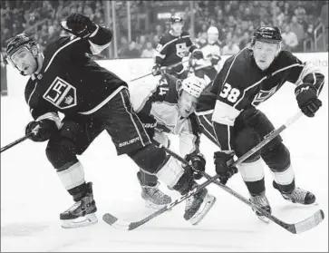  ?? Jae C. Hong Associated Press ?? COLORADO AVALANCHE center Carl Soderberg finds himself uncomforta­bly caught in the middle between Kings defensemen Alec Martinez, left, and Paul LaDue during the first period.