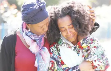  ?? —Reuters photo ?? A woman who identified herself as Pretana Morgan, the mother of Rhyhiem Ainsworth Barton, is comforted as she visits the scene where her son died in London.