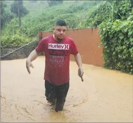  ?? Stephanie Rojas Associated Press ?? A FLOODED street in Cayey, Puerto Rico. Fiona brought two feet of rain to parts of the island before hitting the Turks and Caicos. It could pass Bermuda next.