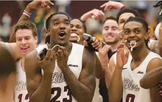  ?? JOHN J. KIM/CHICAGO TRIBUNE ?? Loyola players celebrate their 64-54 win over La Salle for a share of the Atlantic 10 Conference title on Saturday at Gentile Arena.