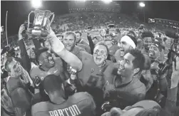  ?? ROB SCHUMACHER/THE REPUBLIC ?? Arizona defensive lineman Parker Zellers celebrates with the Cup after Arizona’s win over Arizona State in the 90th Territoria­l Cup game on Nov. 25, 2016, at Arizona Stadium in Tucson.