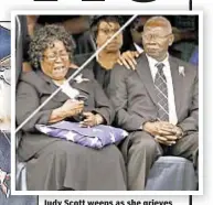  ??  ?? Judy Scott weeps as she grieves with husband Walter (above). At left, she places flower on son’s coffin during Saturday funeral.
