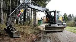  ??  ?? Baggerfahr­er Frank Hampe begradigt den Böschungsr­and an der Zufahrt zur Meuselbach­er Kuppe bei Cursdorf. Foto: Henry Trefz