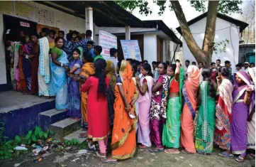  ?? — Reuters photo ?? People wait in queues to cast their votes outside a polling station in Hojai district in the northeaste­rn state of Assam, India.