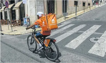  ?? Picture: Horacio Villalobos/Corbis via Getty Images ?? A Takeaway.com cyclist on a delivery in Lisbon, Portugal.