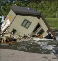  ?? ASSOCIATED PRESS FILE PHOTO ?? A house sits in Rock Creek after floodwater­s washed away a road and a bridge in Red Lodge, Mont., on June 15.