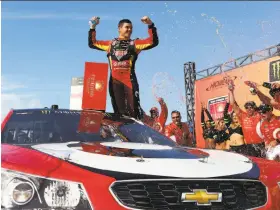  ?? Sarah Crabill / Getty Images ?? Kyle Larson likes the view from his perch, standing on his car in Victory Lane after winning the NASCAR Cup race at Michigan Internatio­nal Speedway.