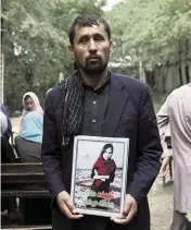  ??  ?? A father brought a photo of his deceased daughter to the demonstrat­ion hoping for more security at schools.