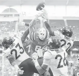  ?? MICHAEL REAVES/GETTY ?? The Hurricanes’ Will Mallory tips a pass that would be caught by Mark Pope for a touchdown Saturday at the end of the first half against Virginia Tech at Hard Rock Stadium.