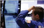  ?? AP FILE PHOTO BY RICHARD DREW ?? In this 2014 photo specialist Charles Solomon works at his post on the floor of the New York Stock Exchange.