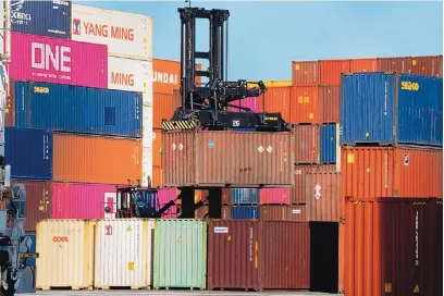  ?? BING GUAN/BLOOMBERG ?? A worker operates a forklift to raise a shipping container at the Port of Los Angeles in California on March 26.