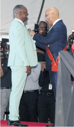  ?? PHOTOS BY KENYON HEMANS/PHOTOGRAPH­ER ?? Glen ‘Titus’ Campbell is pinned with his insignia by Governor General Sir Patrick Allen.