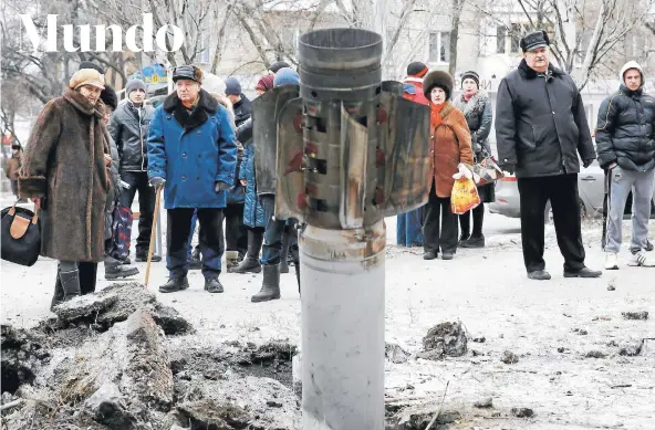  ?? FOTO: REUTERS ?? Un grupo de personas observa ayer los restos de un rocket en la calle del pueblo de Kramatorsk.