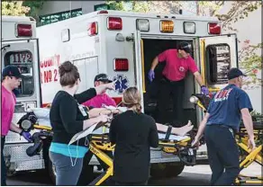  ??  ?? Attack: Paramedics help a victim of the shooting at the college yesterday