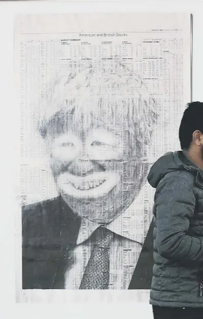  ??  ?? 0 A man walks past a poster in Glasgow showing Boris Johnson made up like a clown as the Coronaviru­s