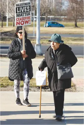  ?? (Jeff Kowalsky/AFP via Getty Images) ?? AN ATTENDEE stands with a sign attached to her cane during an interfaith prayer vigil for Aaron Bushnell outside the Henry Ford Centennial Library in Dearborn, Michigan last week. Bushnell died in February after self-immolating outside the Israeli embassy in Washington in protest over the war in Gaza.