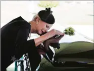  ?? DAVID HUME KENNERLY/MCCAIN FAMILY VIA AP ?? In this photo provided by the family of John McCain, Cindy McCain lays her head on the casket during a burial service at the cemetery at the United States Naval Academy in Annapolis, Md., on Sunday.