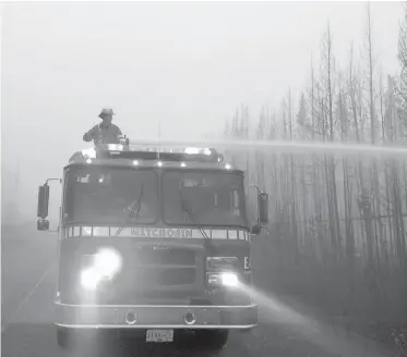  ??  ?? A capital region fire crew battles a wildfire near 150 Mile House in August. While firefighte­rs were on the front lines, many others helped in different ways, writes Charla Huber.