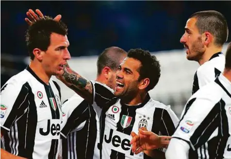  ?? AFP ?? Juventus’ forward Mario Mandzukic (left) is congratula­ted by teammates after scoring during the Serie A 2-0 victory against Empoli at the Juventus Stadium in Turin on Saturday.