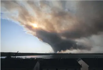  ?? KELLY CLARK, THE CANADIAN PRESS ?? Thick plumes of heavy smoke fill the Halifax sky as an out-of-control fire in a suburban community quickly spread on Sunday, engulfing multiple homes and forcing the evacuation of residents.