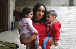  ??  ?? Islam Maytat from Morocco poses for a photo with her children in the Kurdish-majority city of Qamishli in northern Syrian after she escaped from ISIS territory following three traumatic years living in the group’s so-called ‘caliphate’. — AFP