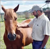  ??  ?? Eldon Fry pats his horse, Dudley, whom he uses on the farm, while he works cattle at Fry’s East Fork Cattle Co. in Quitman.