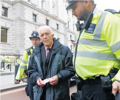  ?? Photo / AP ?? Phil Kingston is escorted by police after being detained during a London protest in 2019.