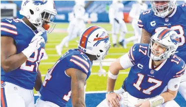  ?? AP ?? Bills QB Josh Allen (17) celebrates with teammate Stefon Diggs (14), Dion Dawkins (73), and Zack Moss (20) after connecting with Diggs for a touchdown during the second half on Saturday.