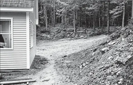  ?? TIM CARTER/TCA ?? Stormwater is going to rush down the hill on the right and overwhelm this new home. Re-sloping the soil around the house can help resolve the issue.