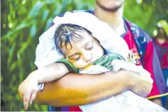  ??  ?? A Honduran migrant heading in a caravan to the US, carries a baby on the road linking Ciudad Hidalgo and Tapachula, Chiapas state, Mexico.