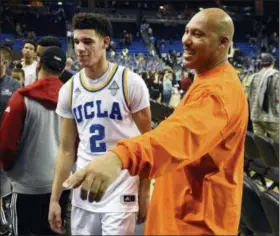  ?? MICHAEL OWEN BAKER— ASSOCIATED PRESS ?? In this Nov. 20, 2016 file photo, UCLA’s Lonzo Ball (2) walks by his father LaVar Ball, right, to greet family members.