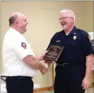  ?? Staff photograph by Sally Carroll ?? Fire Chief Rob Taylor presents Wade Canfield the “Firefighte­r of the Year” award.