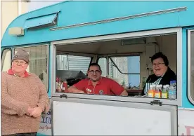  ??  ?? The Lions’ new caravan selling sausage and onions at the latest community market manned by Andrew and Lindy Thompson with John Forbes.